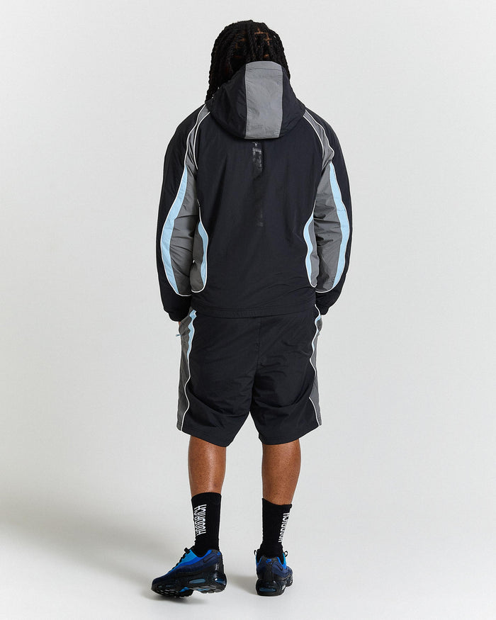 Person wearing a black and grey jacket with a hood on a white background
