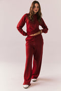 Full body look of model wearing Sandyy Crimson Red Trousers with coordinating hoodie.