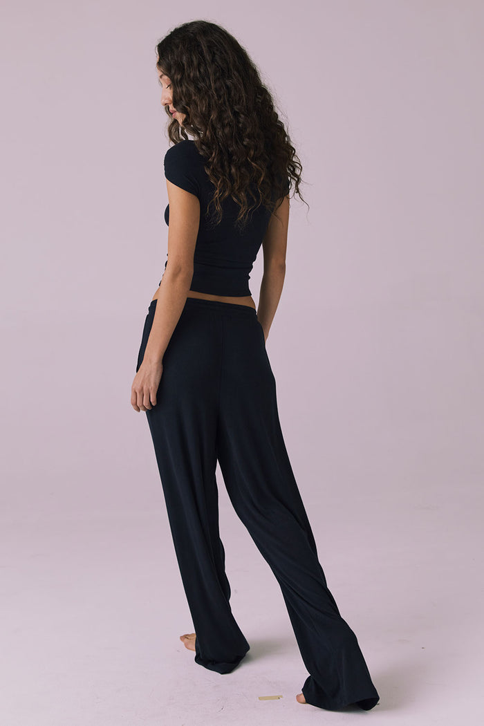 Chaser Sandyy Licorice Black Trouser back walking view with matching Kimpton Licorice Tank showing easy pull on waistband and fluid wide leg movement