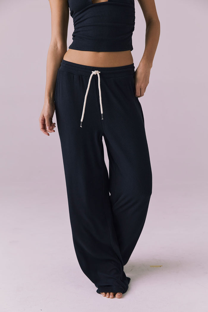 Chaser Sandyy Licorice Black Trouser front walking view from waist down showing long wide leg hem pooling slightly at the floor