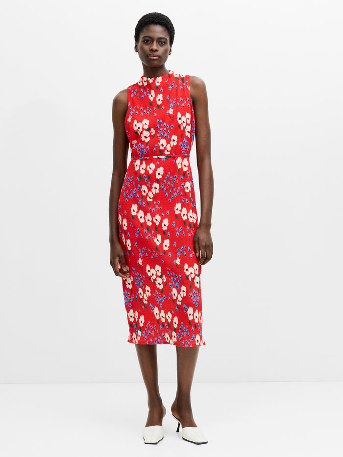 A woman wearing a red sleeveless, bodycon midi dress with a floral print and high neck.