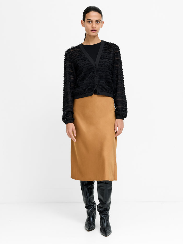 A woman wearing a Eco-blend satin bronze Skirt with a high waisted elasticated waistband and a midi length straight fit.