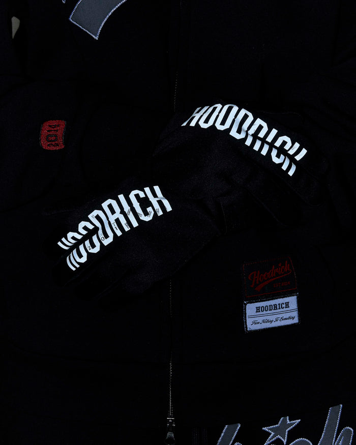 Black jacket with 'Hoodrich' branding on sleeves and chest, close-up view.