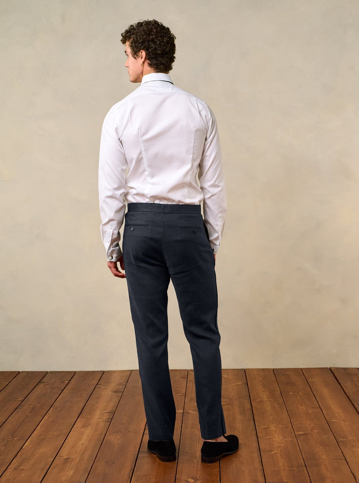 Back view of man in shadow black linen tuxedo pants and white shirt