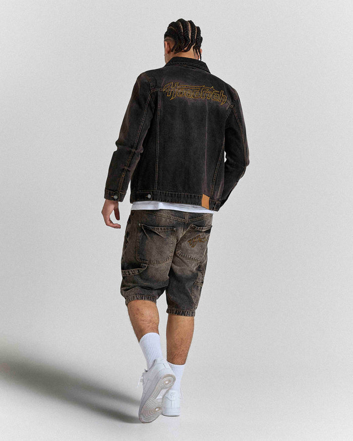 Model seen from behind wearing regular fit black rust washed denim jorts and a matching jacket.