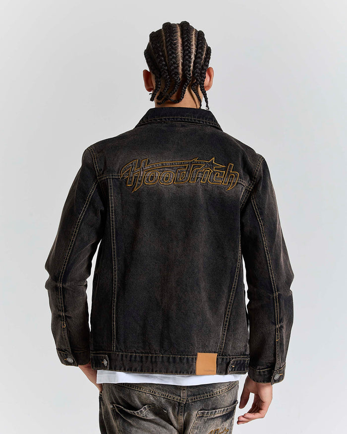 Model seen from behind wearing a regular fit black rust washed denim jacket.