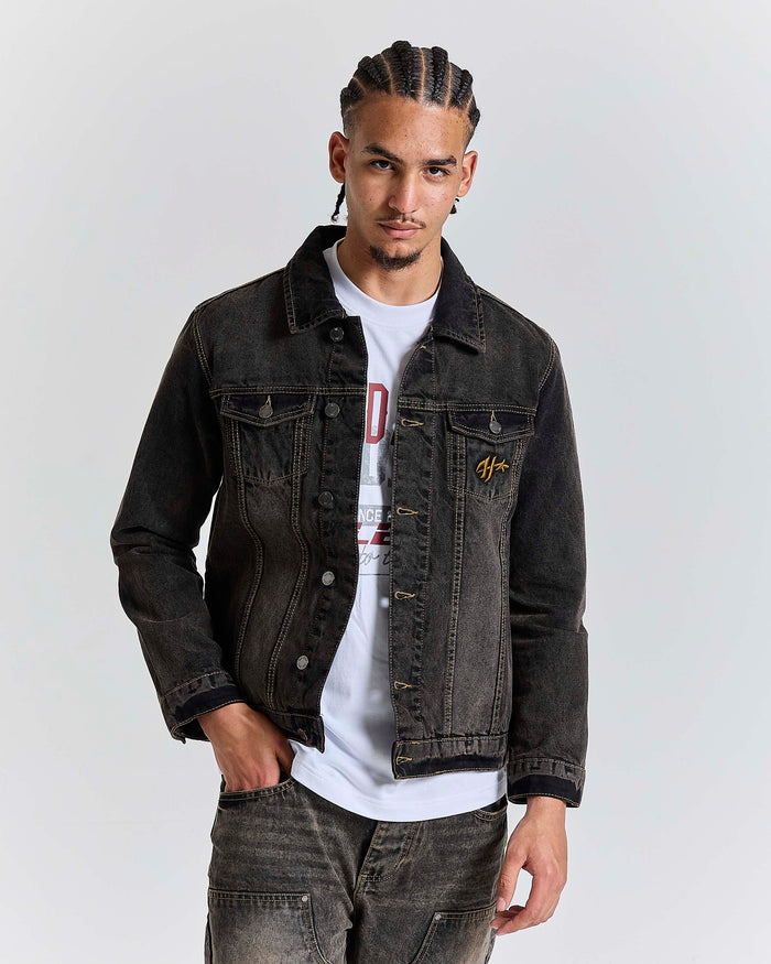 Model wearing a regular fit black rust washed denim jacket with Hoodrich logo embroidery on the chest pocket.