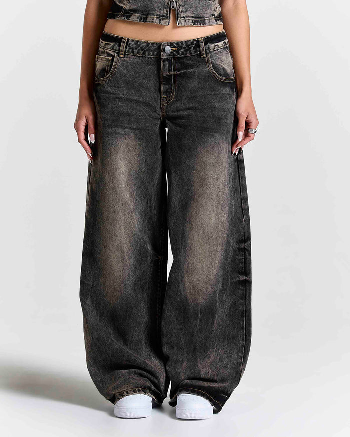 Female model wearing wide-leg, rust-colored wash jeans.