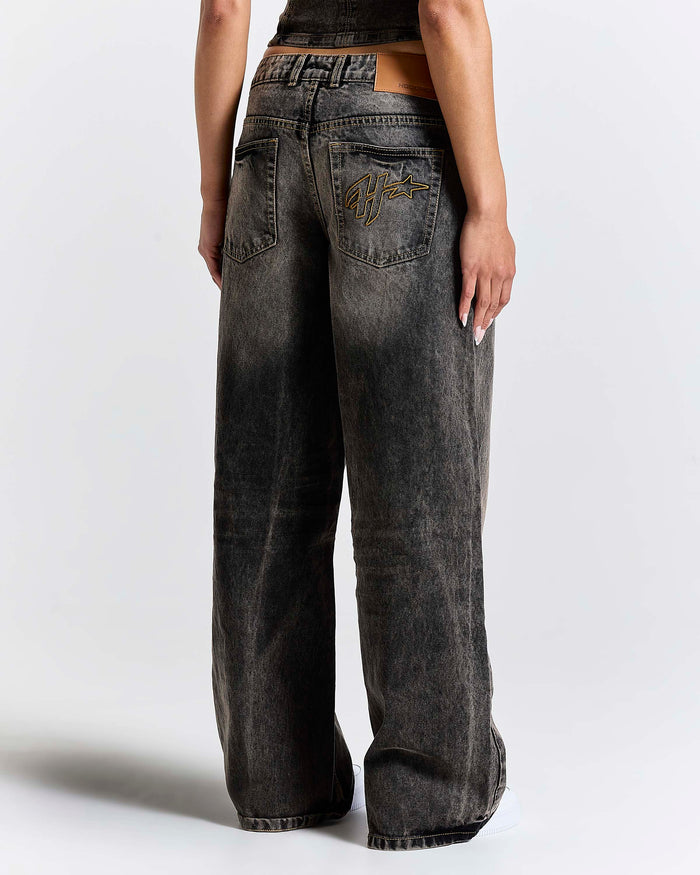 Person wearing wide-leg jeans on a plain background