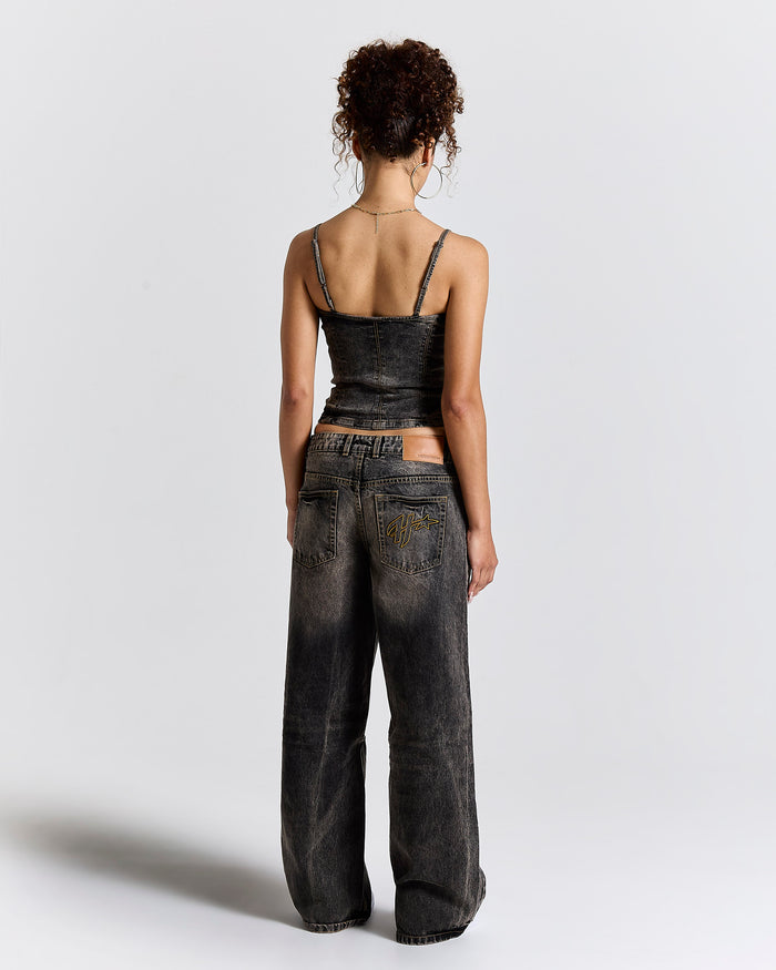 Back view of a female model wearing fitted, rust-colored wash jeans.
