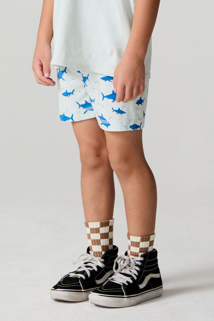 Side angle view of a boy wearing the Chaser Shark Around Shorts on a neutral background