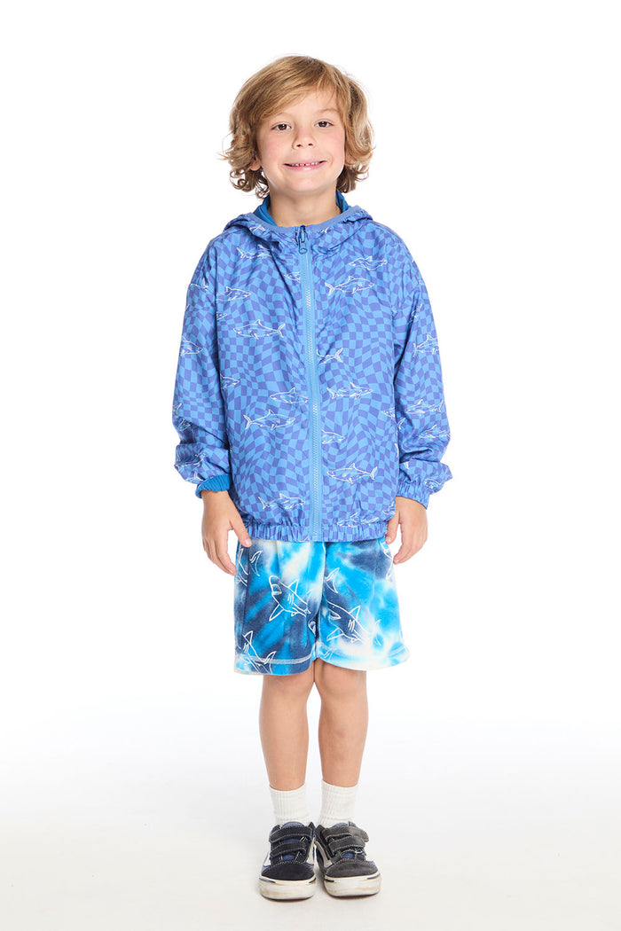 Full body view of boy wearing the Chaser Kids Shark Check Zip Up Hoodie and Shark Bite Shorts styled with white crew socks and navy sneakers on a white background