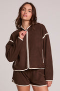 Front view of a woman wearing the Chaser Sharun Worn Brown Jacket on a neutral background