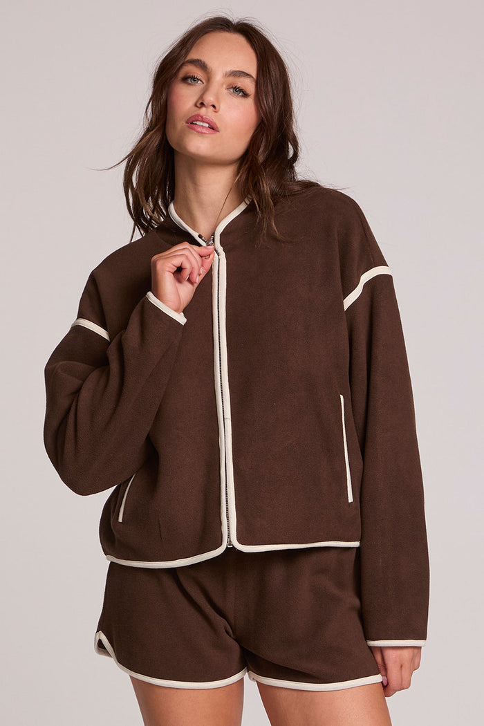 Front view of a woman wearing the Chaser Sharun Worn Brown Jacket on a neutral background