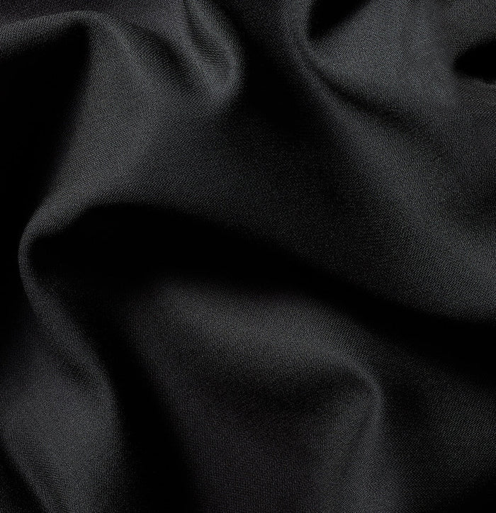 Close-up of black tuxedo fabric with soft draped folds