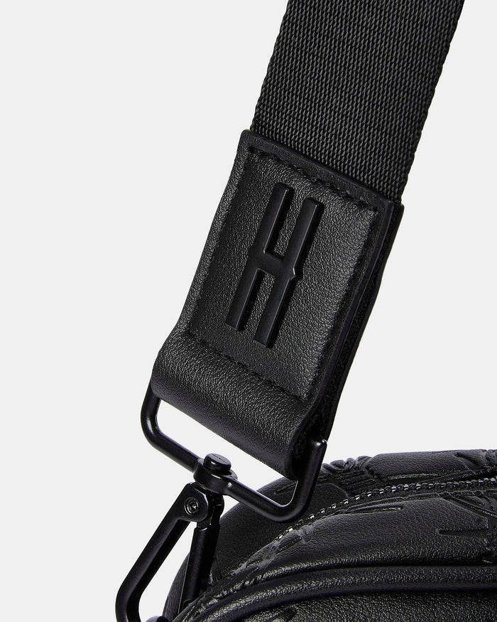 Close-up of a black strap with a logo on a white background