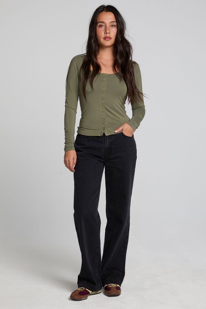 A full body front view of a woman wearing the Chaser Silva Forager Green Fullsleeve Top on a neutral background