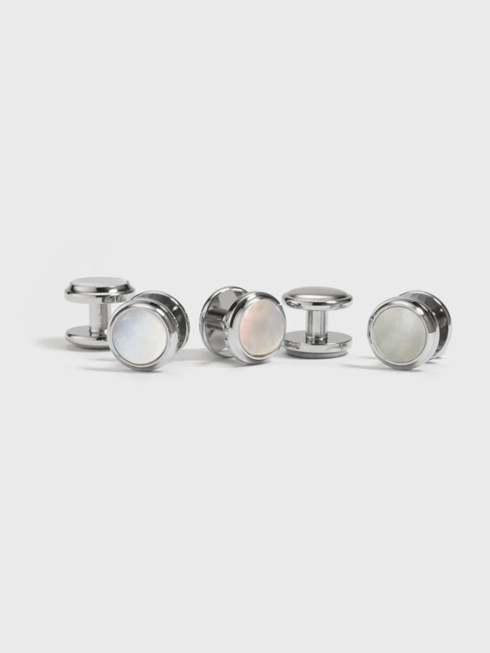 Set of silver shirt studs with mother-of-pearl faces on light grey background