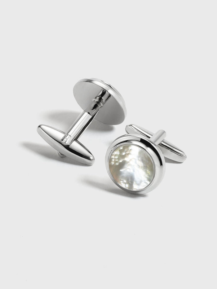 Silver cufflinks with round mother-of-pearl face, pair on light grey background