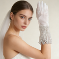 Silver sequin fringe bridal gloves with sheer fabric and sparkling tassel cuffs for wedding ceremony and evening styling.