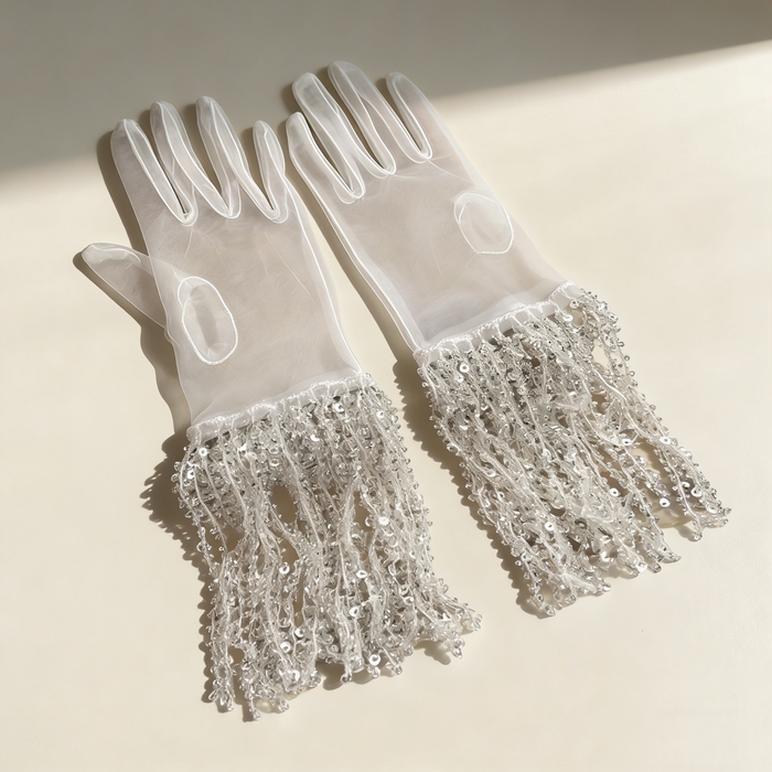 Silver sequin fringe bridal gloves with sheer fabric and sparkling tassel cuffs for wedding ceremony and evening styling.