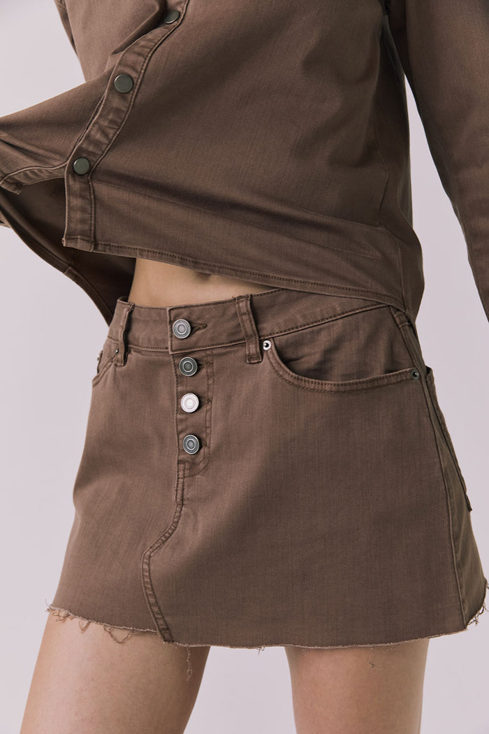 Angled front view of the Chaser Sloane Cognac Wash Mini Skirt showing button fly and relaxed mini silhouette