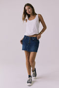 Full body front view of the Chaser Sloane Indigo Wash Mini Skirt featuring a button-front design and raw hem