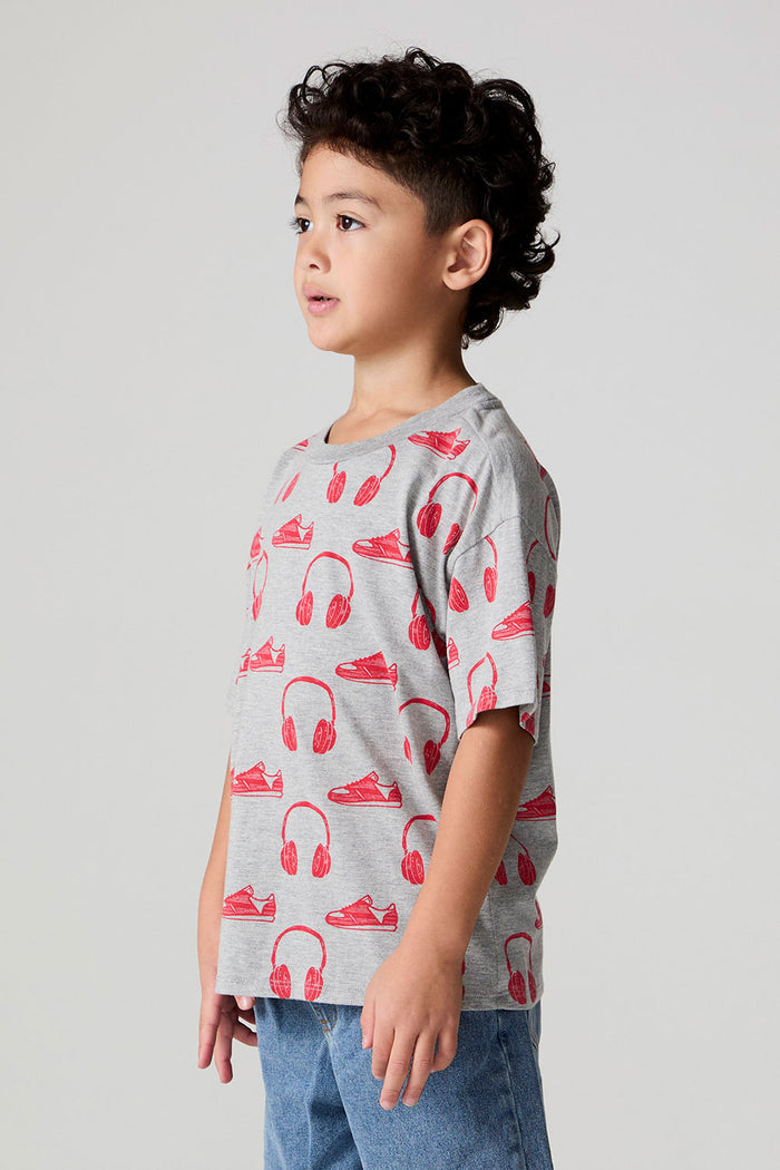 Side angle view of a boy wearing the Chaser Sneaks and Headphones Tee on a neutral background