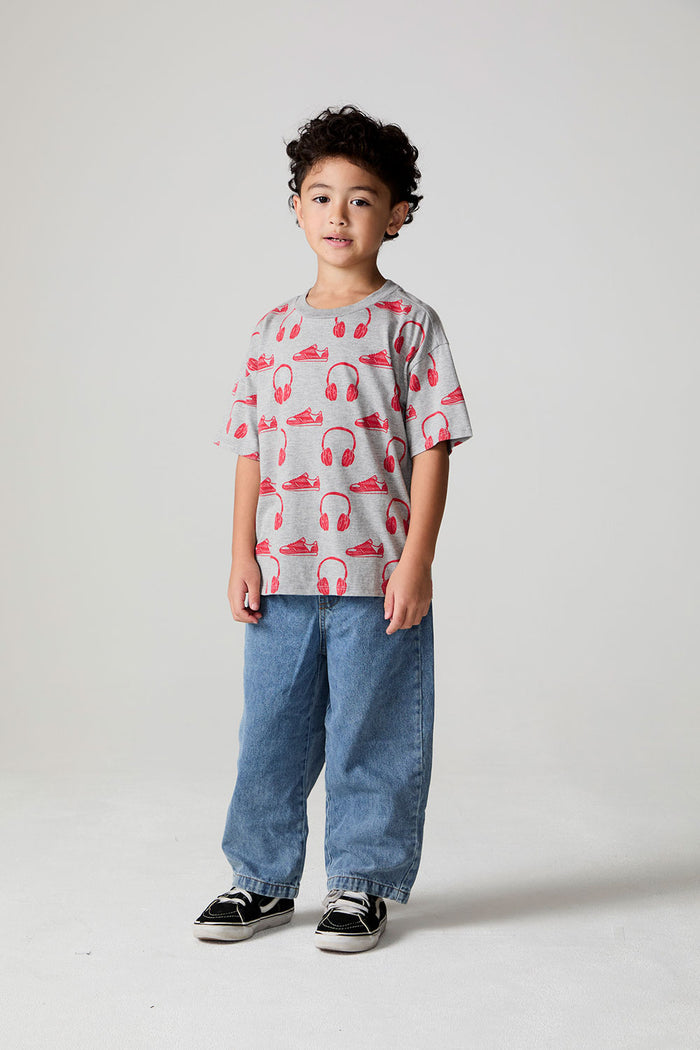 Full body side angle view of a boy wearing the Chaser Sneaks and Headphones Tee on a neutral background
