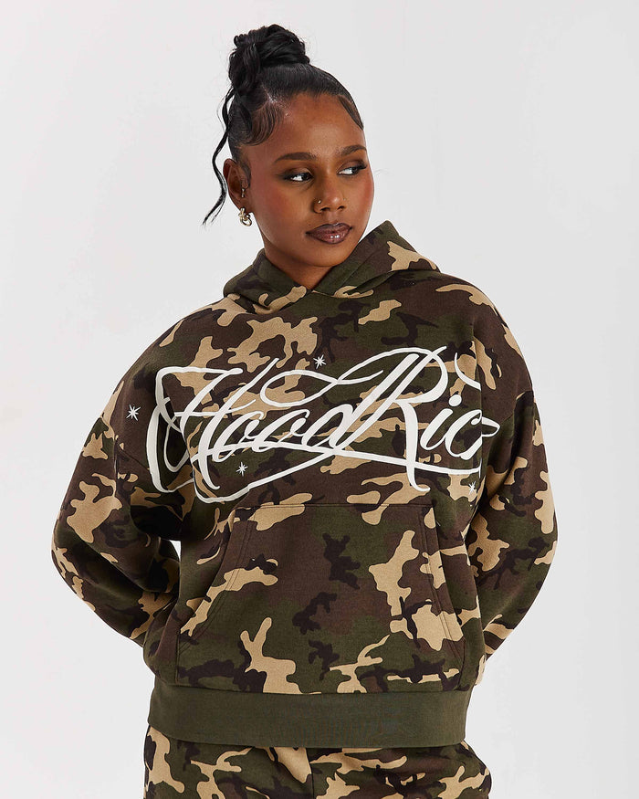 Person wearing a camouflage hoodie with 'Hood Rich' branding on a white background