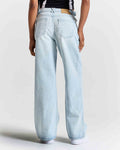 Light blue jeans worn by a person on a plain background