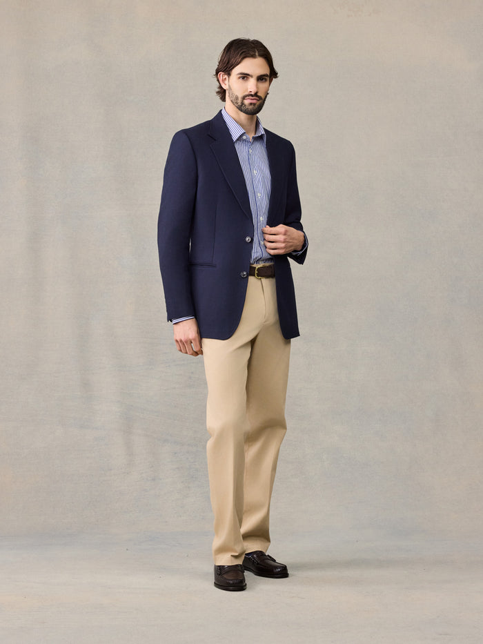 Man in navy sportcoat, striped shirt, and tan trousers, front full-body view