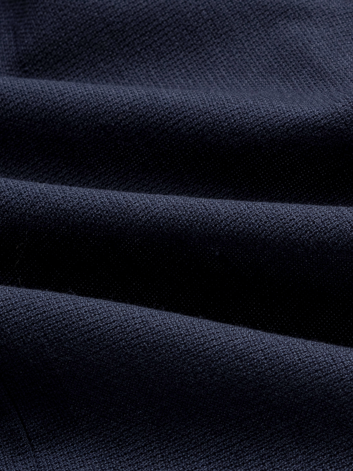 Close-up of navy sportcoat fabric with soft draped folds