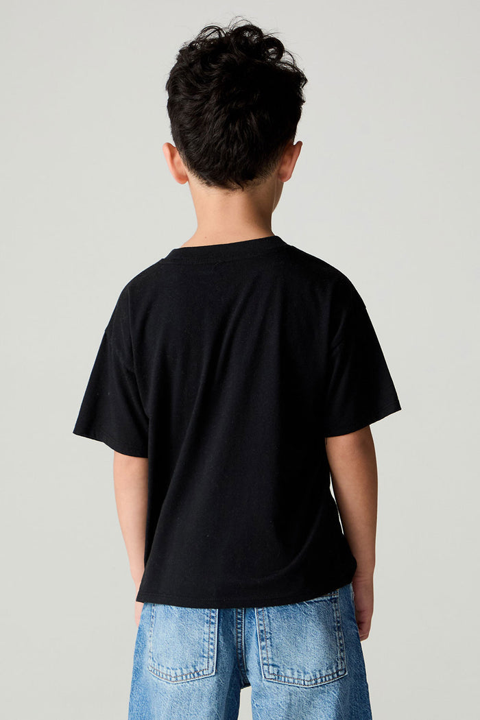 Back view of a boy wearing the Chaser Spooky Friends Boys Tee on a neutral background with jeans
