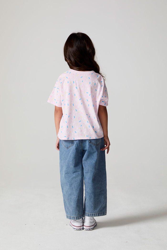 Full body back view of a girl wearing the Chaser Sprinkle Party Tee on a neutral background