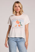 Front view of a woman wearing the Chaser Spritzing The Day Away Tee and jeans on a neutral background