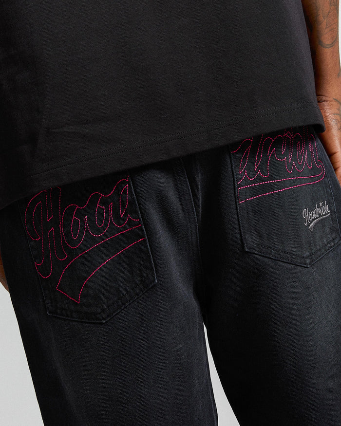 Black pants with red embroidery on a gray background