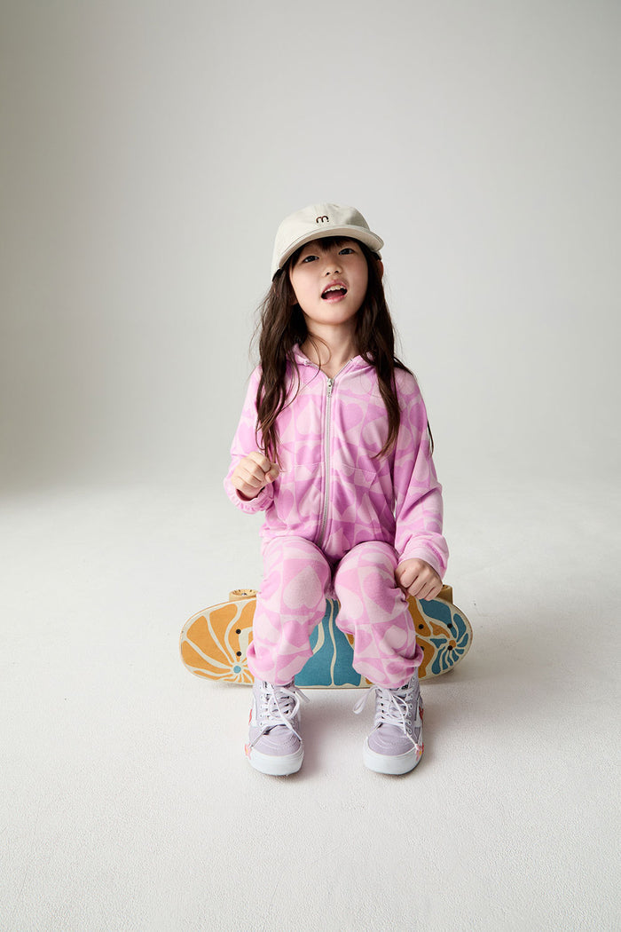 Front view of a girl wearing the Chaser Straight To The Heart Girls Hoodie on a neutral background sitting on a skateboard