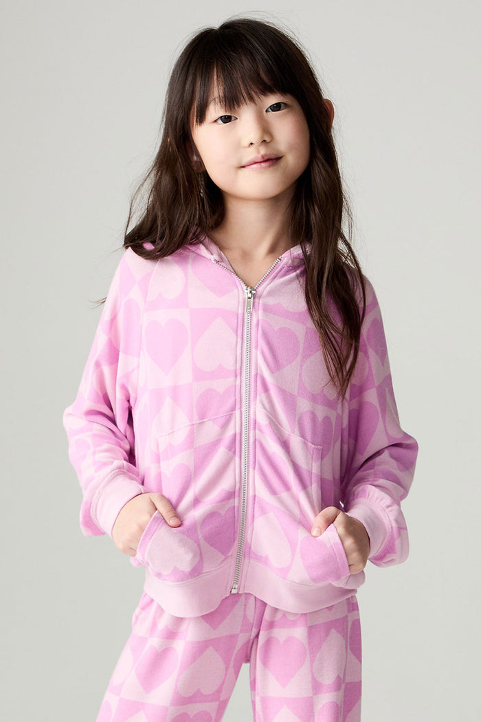 Front view of a girl wearing the Chaser Straight To The Heart Girls Hoodie on a neutral background with matching pants and hands in pockets