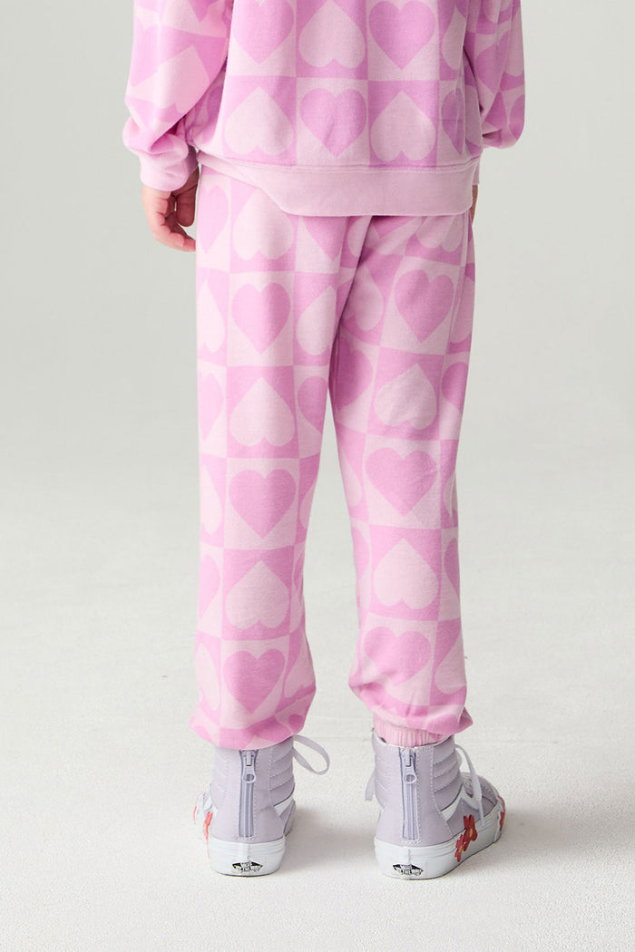 Back view of a girl wearing the Chaser Straight To The Heart Girls Jogger and top on a neutral background