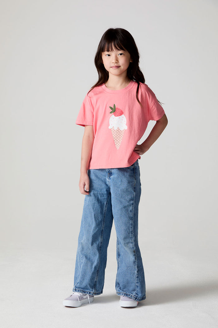 Full body front view of a girl wearing the Chaser Strawberry Ice Cream Tee and jeans on a neutral background