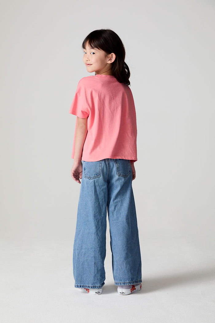 Full body back view of a girl wearing the Chaser Strawberry Ice Cream Tee on a neutral background