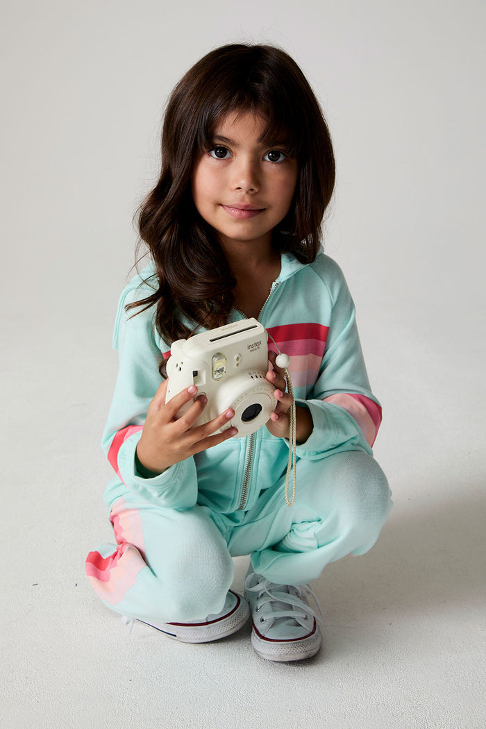 Front view of a girl wearing the Chaser Stripes for Days Hoodie on a neutral background crouching down holding a camera