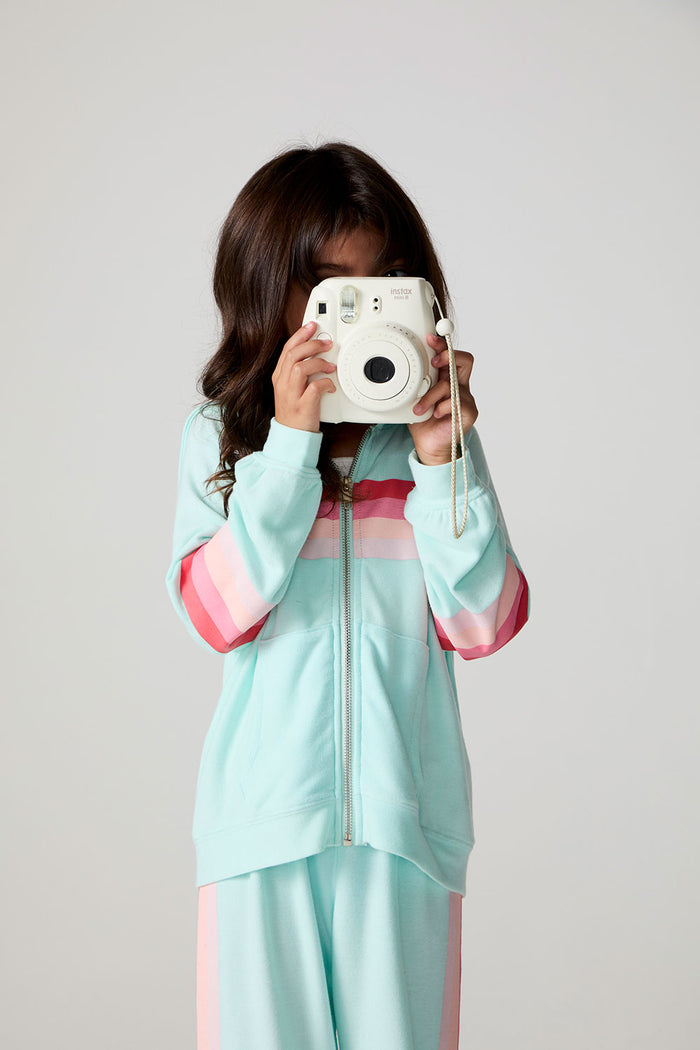 Front view of a girl wearing the Chaser Stripes for Days Hoodie on a neutral background holding a camera