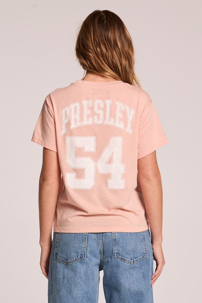 Back view of a woman wearing the Chaser  Sun Records Elvis Collegiate Tour Tee on a neutral background