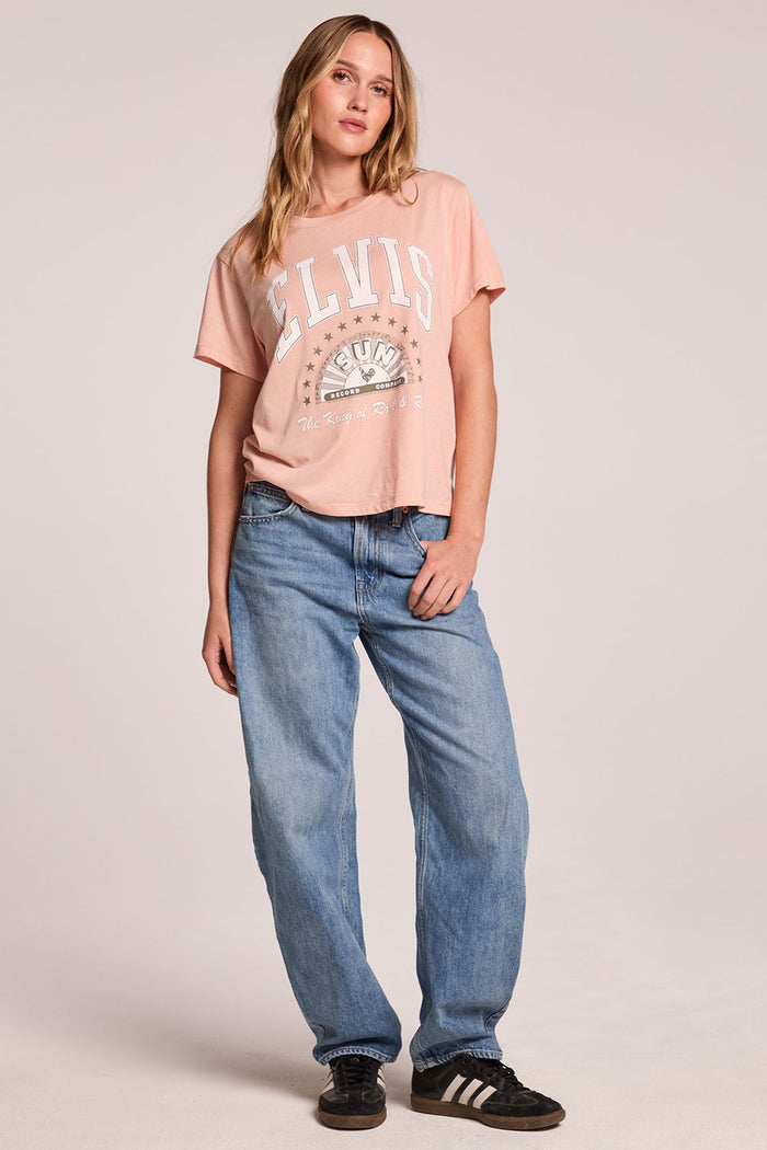 Fu;; body front view of a woman wearing the Chaser  Sun Records Elvis Collegiate Tour Tee and sneakers on a neutral background