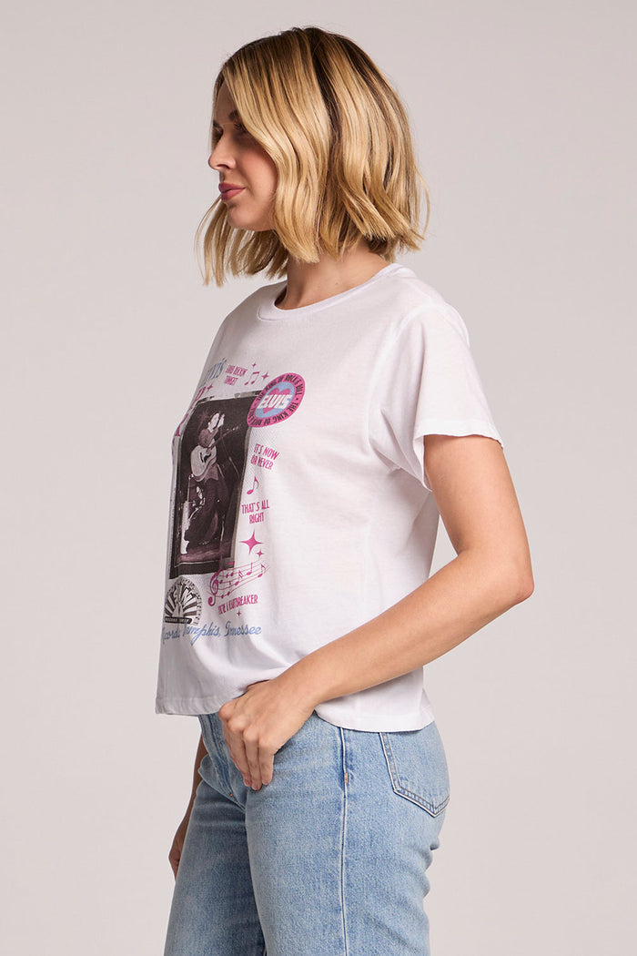 Side view of a woman wearing the Chaser  Sun Records Rock & Roll King Collage on a neutral background with a hand in her pocket