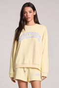 Front  view of a woman wearing the Chaser  Sunkissed Long Sleeve and shorts on a neutral background