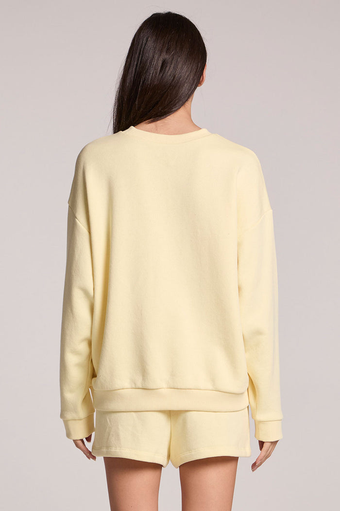 Back view of a woman wearing the Chaser  Sunkissed Long Sleeve on a neutral background