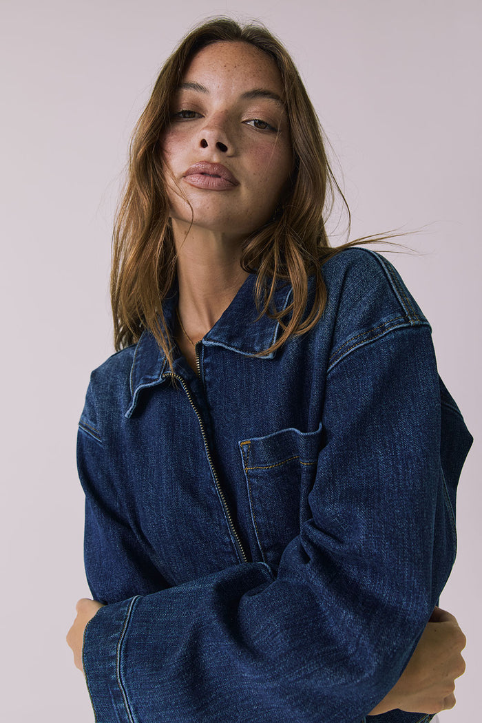 Mid-body front view of the Chaser Sutton Indigo Wash Jacket featuring a zip-front closure and chest pocket detail